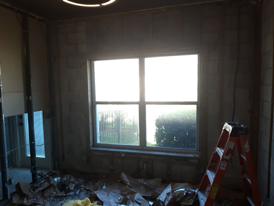 Room stripped to bare block walls with ladder during fire damage restoration